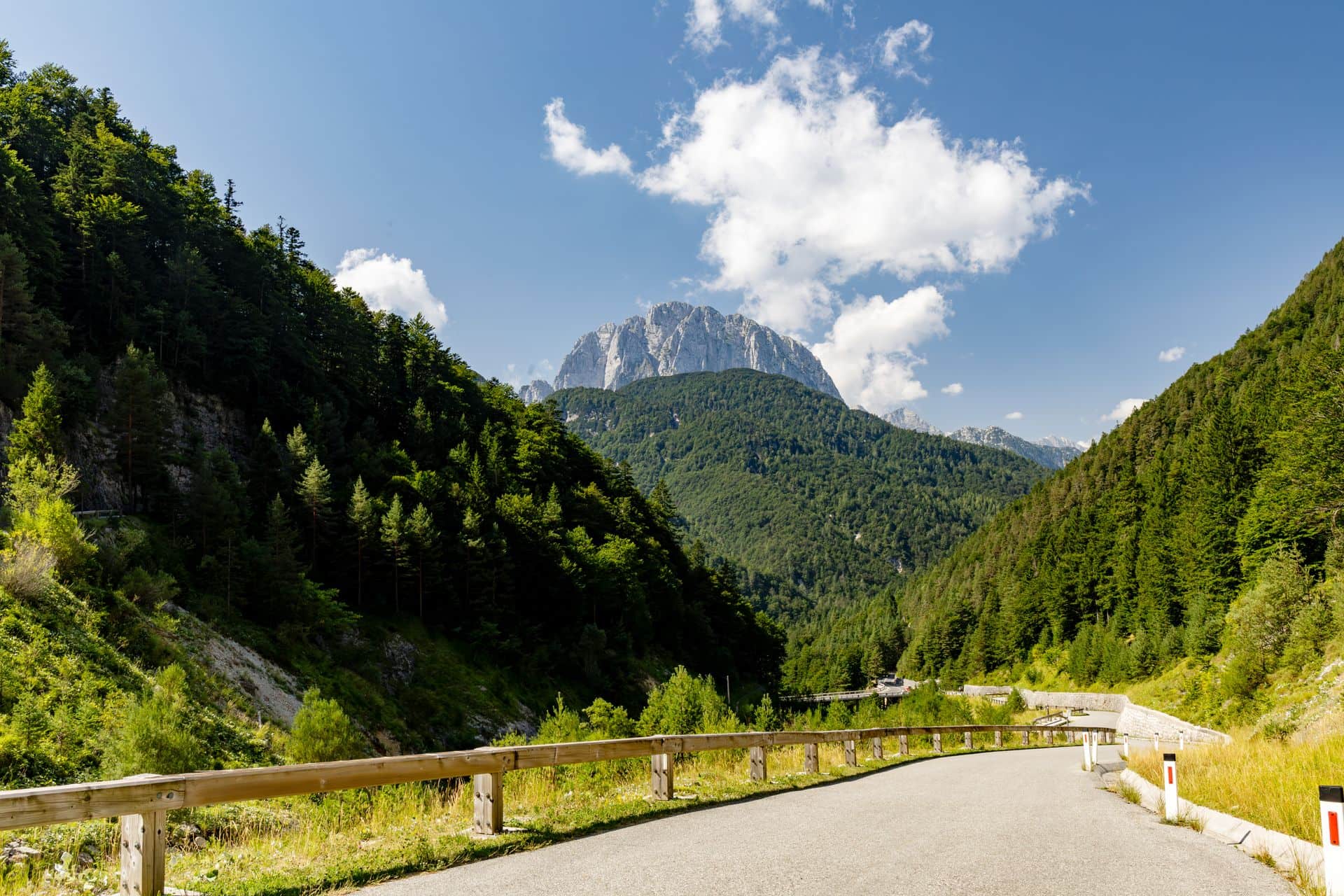 Winding road through the Julian Alps in Slovenia, framed by forest and mountains