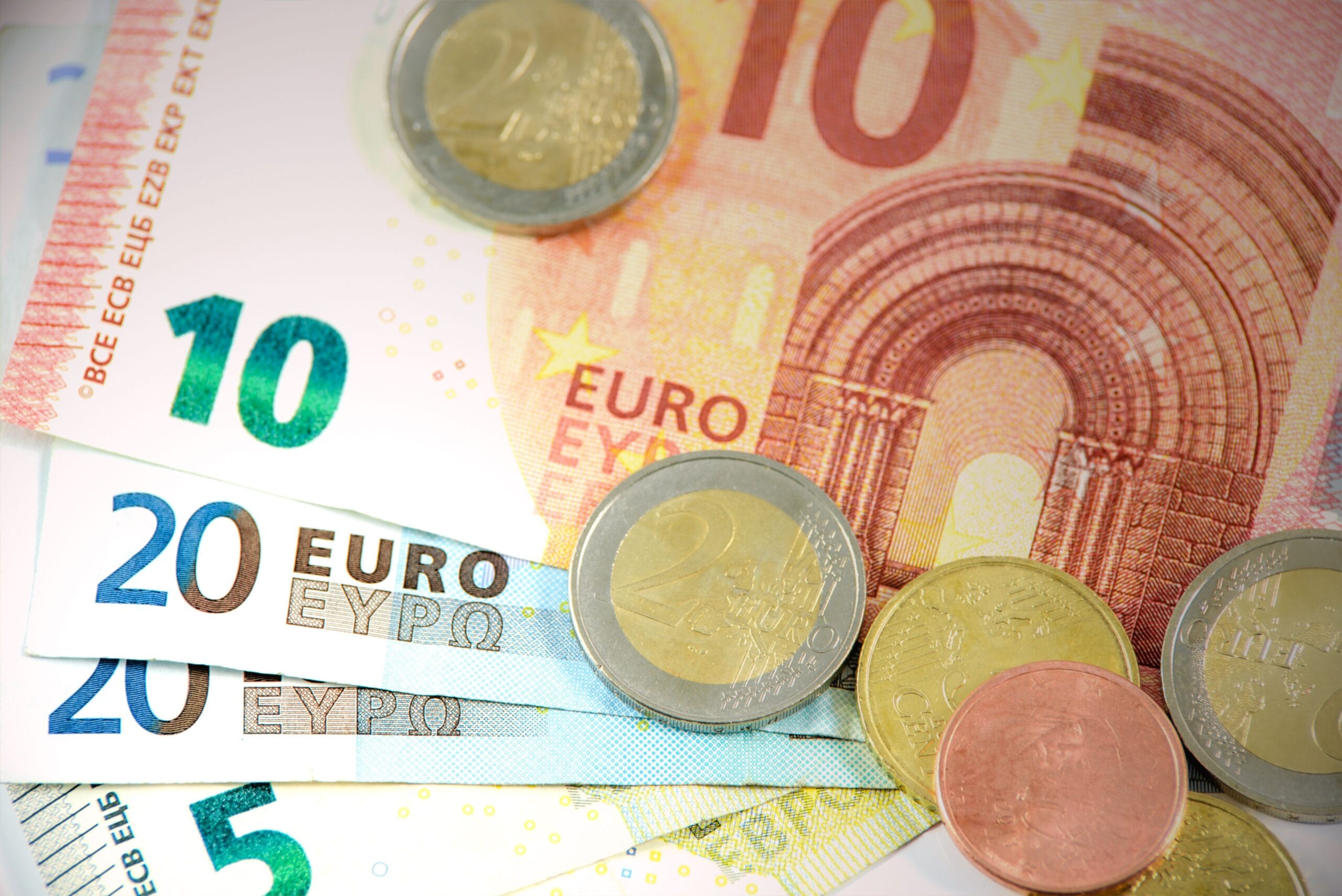 Close-up of euro banknotes and coins, representing cash payment options while travelling in Slovenia