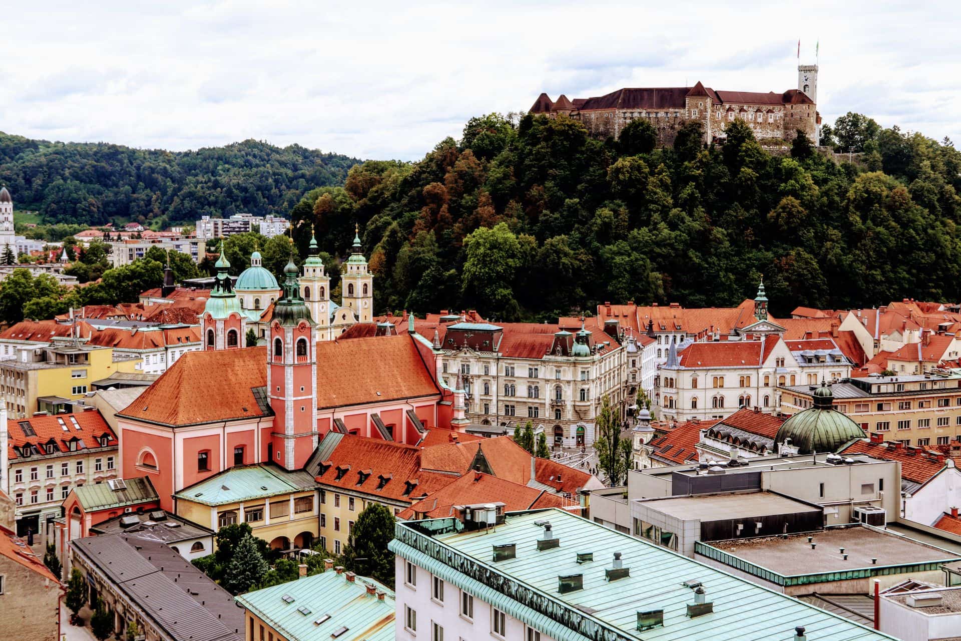 Panoramic view of Ljubljana's old town with Ljubljana Castle on the hill above red-tiled rooftops, Slovenia